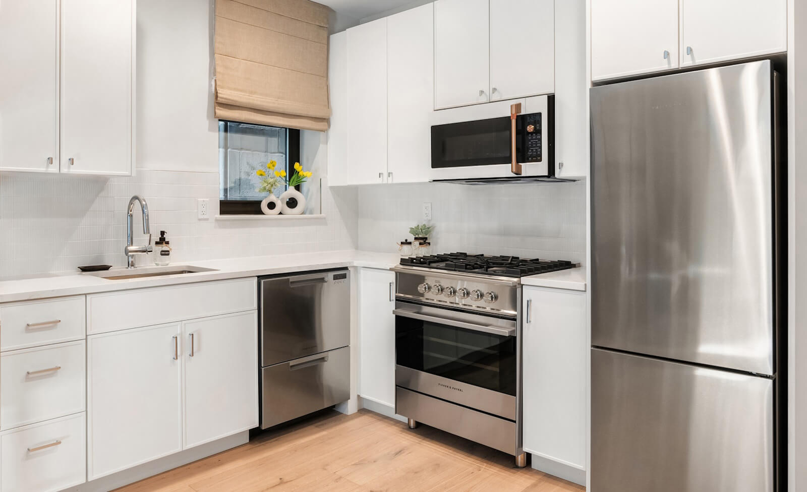 Kitchen with stainless steel appliances in a condo for sale in Hamilton Heights NYC at 463 West 142nd Street condominium.
